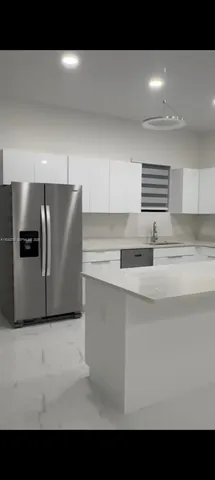 a kitchen with a refrigerator and a sink