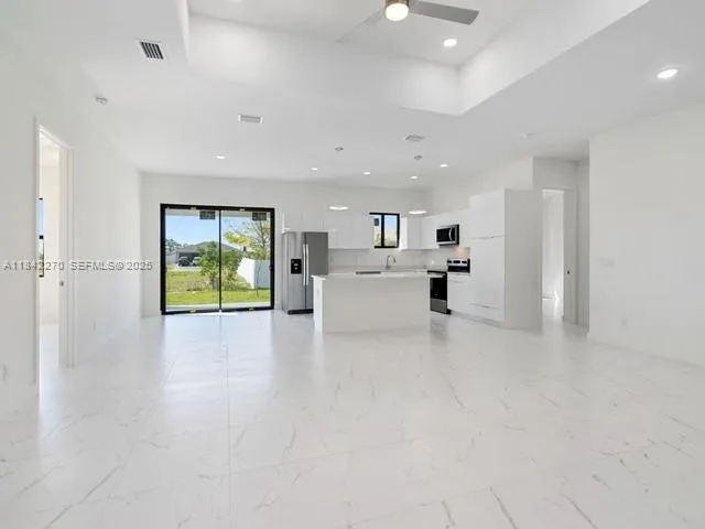 a view of kitchen and hall with stainless steel appliances
