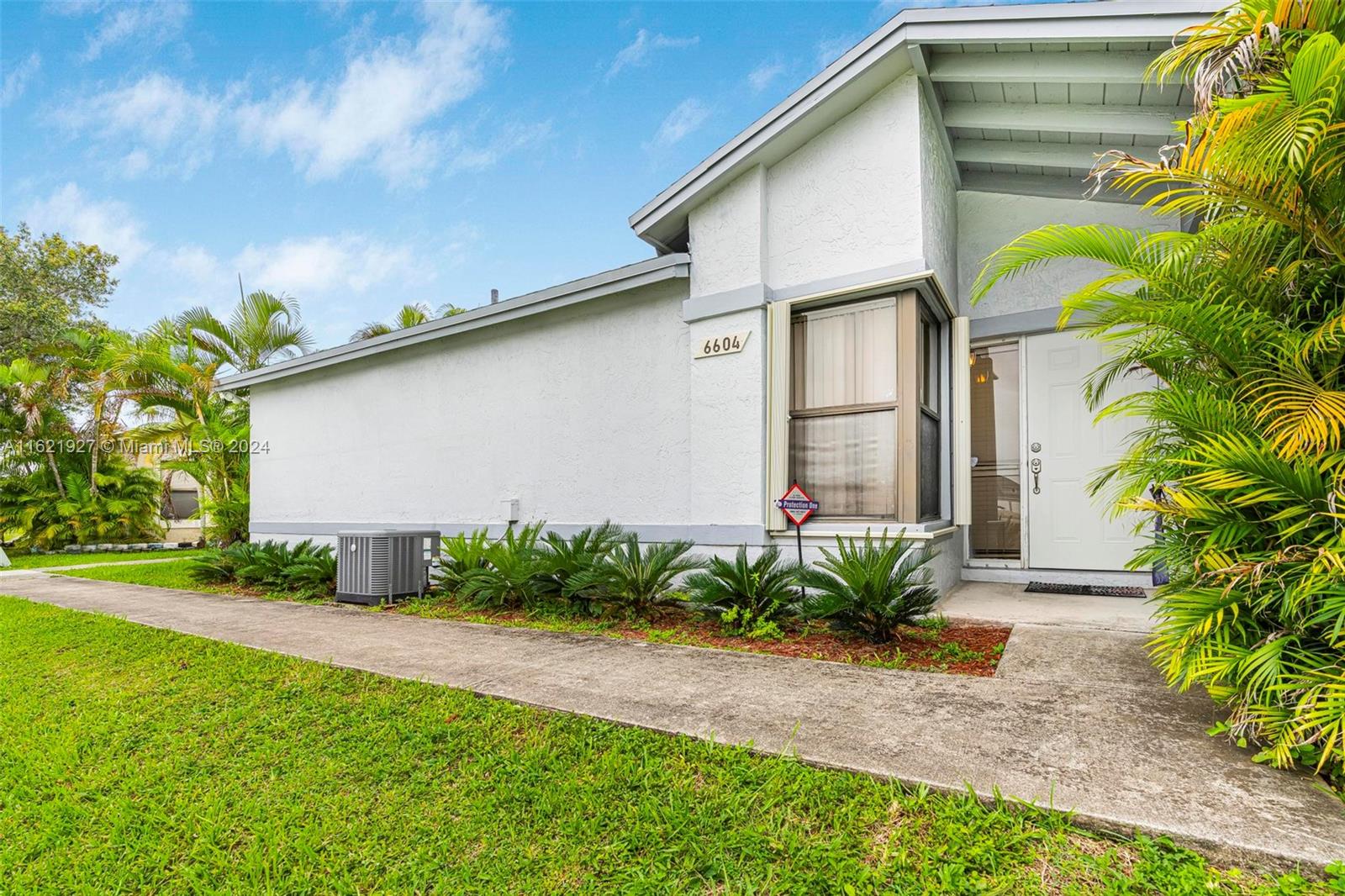 6604 Southwest 152nd Place, Unit 2604 Miami, FL 33193 - Photo 1 of 27 a front view of a house with garden