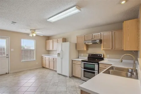 a kitchen with white cabinets and appliances