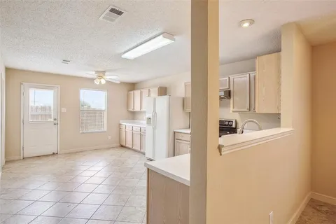 a view of a kitchen with refrigerator and windows