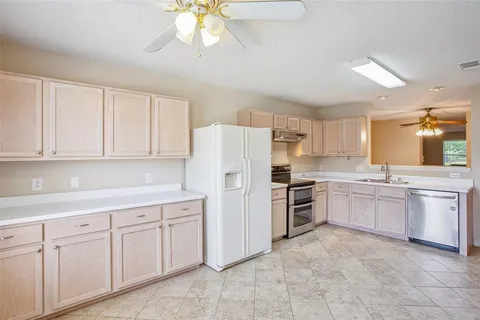 a kitchen with kitchen island granite countertop cabinets and white stainless steel appliances