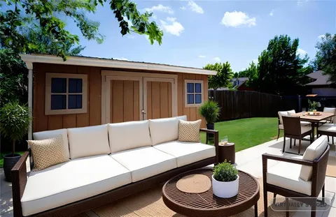 a view of a patio with couches table and chairs with plants and a garden