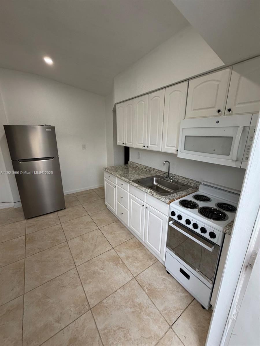 830 Southwest 6th Street, Unit B Hallandale Beach, FL 33009 - Photo 1 of 11 a kitchen with cabinets and steel appliances