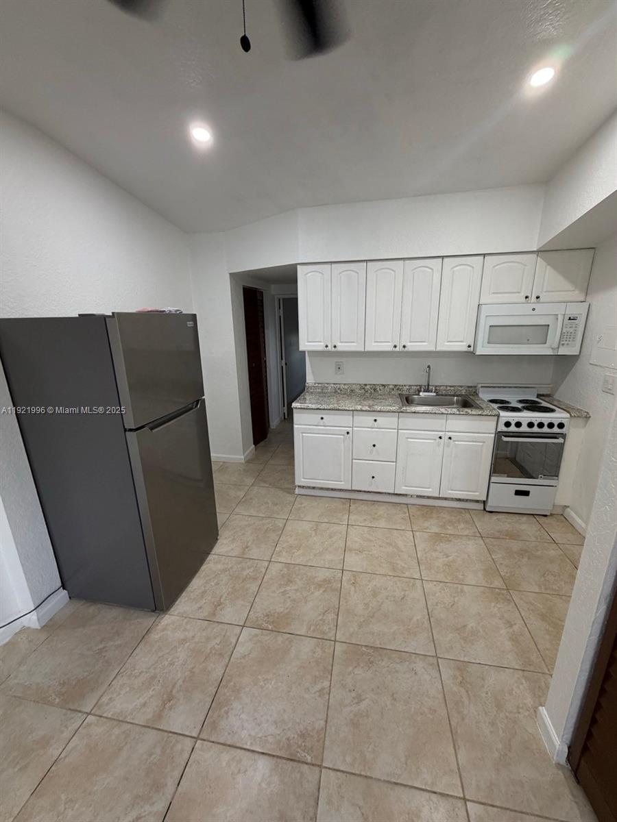 830 Southwest 6th Street, Unit B Hallandale Beach, FL 33009 - Photo 2 of 11 a kitchen with stainless steel appliances a refrigerator sink and cabinets