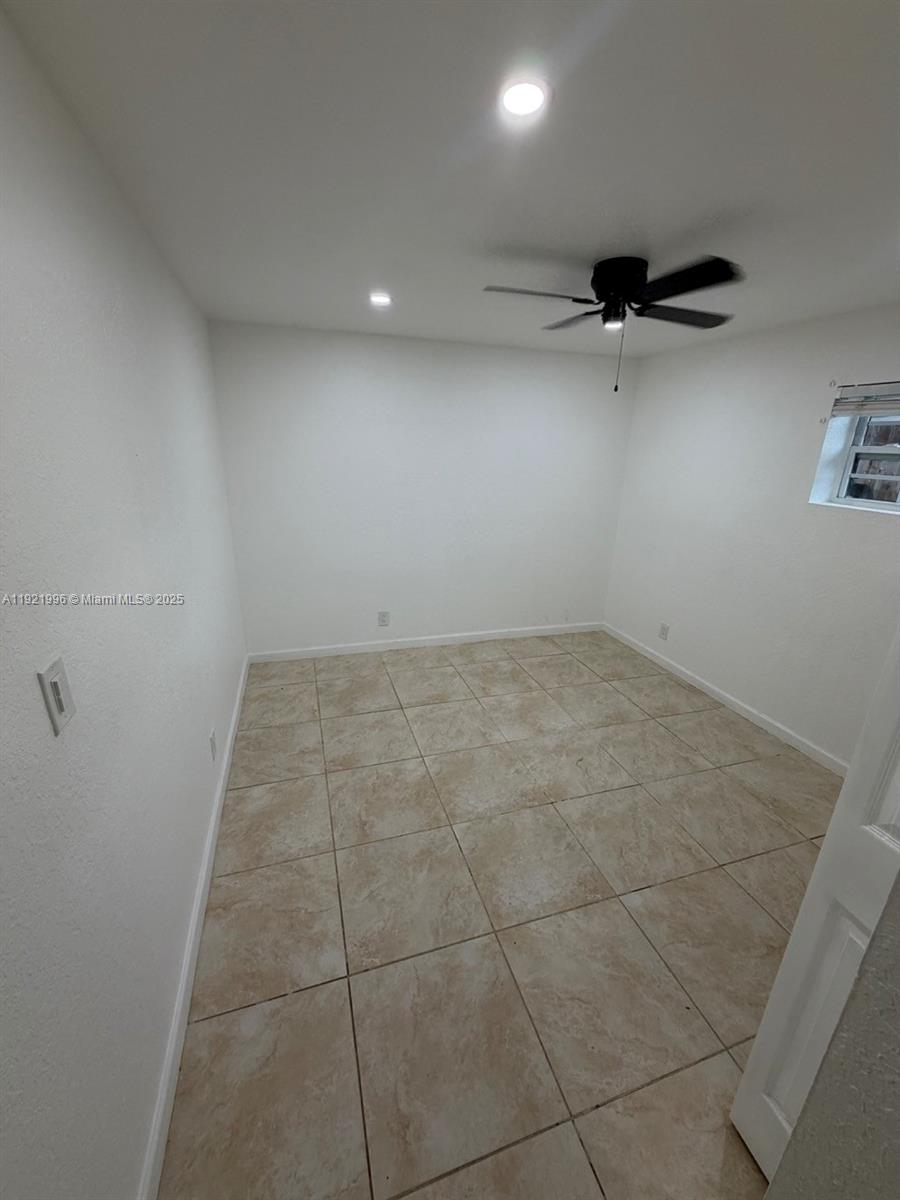 830 Southwest 6th Street, Unit B Hallandale Beach, FL 33009 - Photo 5 of 11 an empty room with a ceiling fan