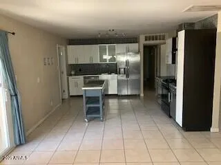 a kitchen with stainless steel appliances kitchen island granite countertop a refrigerator and a sink