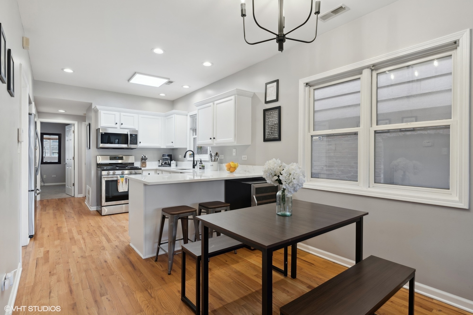 825 South Miller Street, Unit 2 Chicago, IL 60607 - Photo 5 of 15 a kitchen with a dining table chairs refrigerator and cabinets