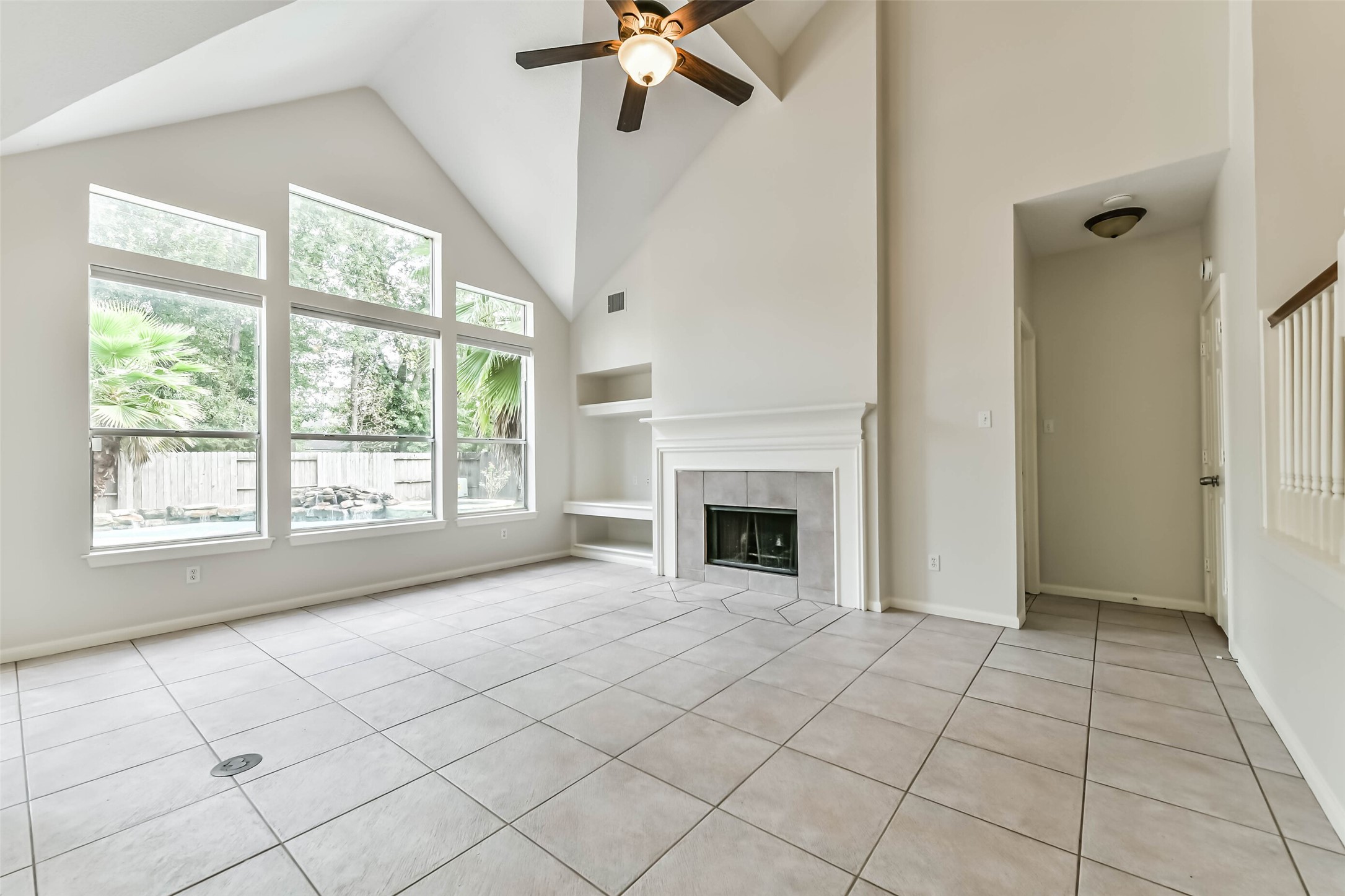 6338 Maple Spring Place Humble, TX 77346 - Photo 9 of 50 Let the backyard become part of your everyday backdrop. Tall windows bring natural light and pool views into the living room, while the fireplace offers a cozy focal point for quiet evenings and conversation.