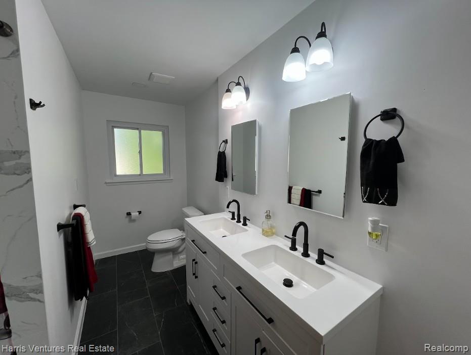 28482 Sutherland Avenue Warren, MI 48088 - Photo 19 of 25 Double vanity with white countertops, integrated sinks, and matte black fixtures