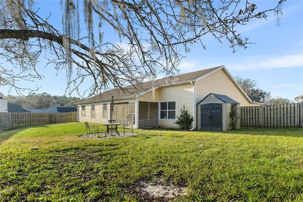 a view of a house with backyard and sitting area
