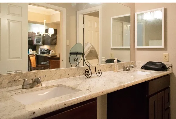 a bathroom with a granite countertop sink and a mirror