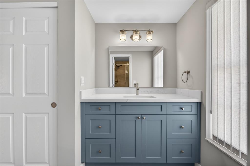 6035 Manasota Key Road Englewood, FL 34223 - Photo 22 of 54 a bathroom with a granite countertop sink vanity and a mirror