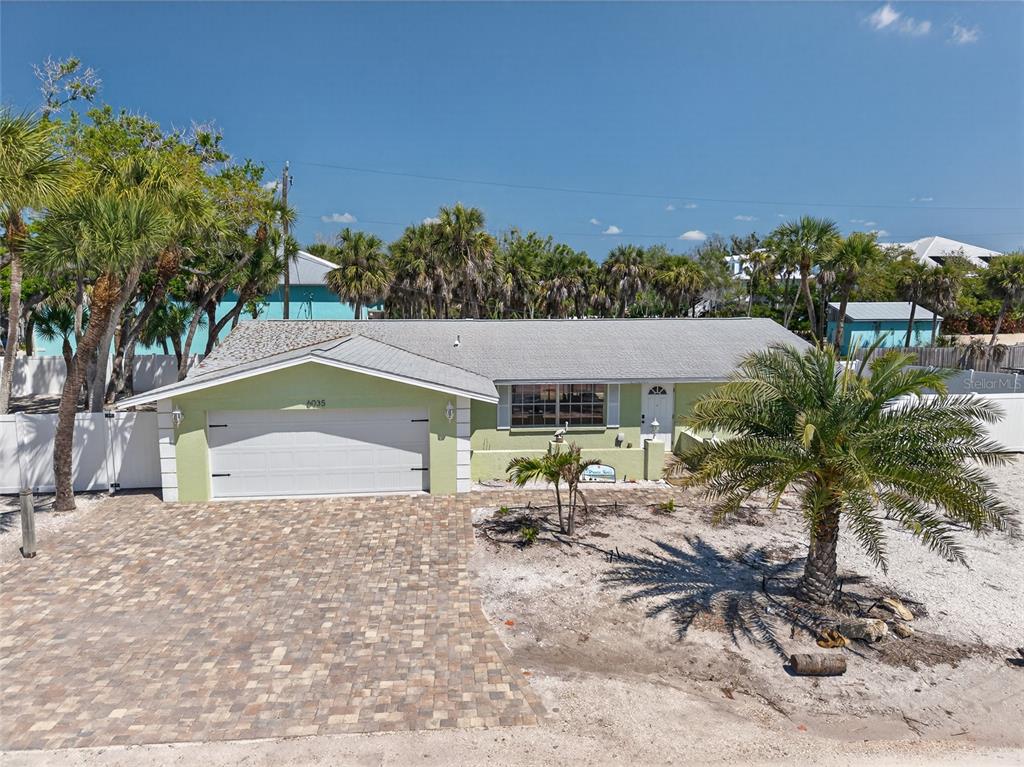 6035 Manasota Key Road Englewood, FL 34223 - Photo 53 of 54 a backyard of a house with table and chairs under an umbrella