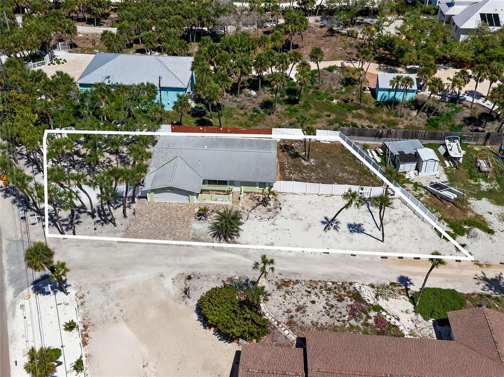 6035 Manasota Key Road Englewood, FL 34223 - Photo 9 of 54 an aerial view of a house with a yard and a large tree