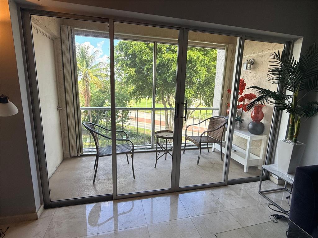 505 Spencer Drive, Unit 210 West Palm Beach, FL 33409 - Photo 2 of 12 a view of a room with a floor to ceiling window and an outdoor view