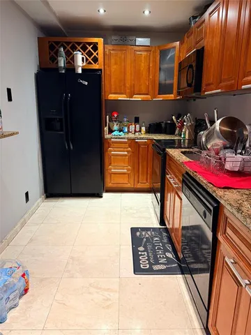 a kitchen with granite countertop a stove and cabinets