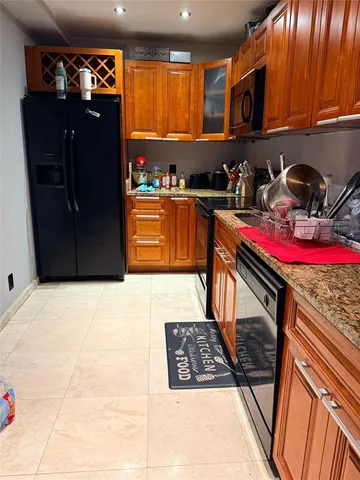 a kitchen with stainless steel appliances granite countertop a refrigerator and a stove