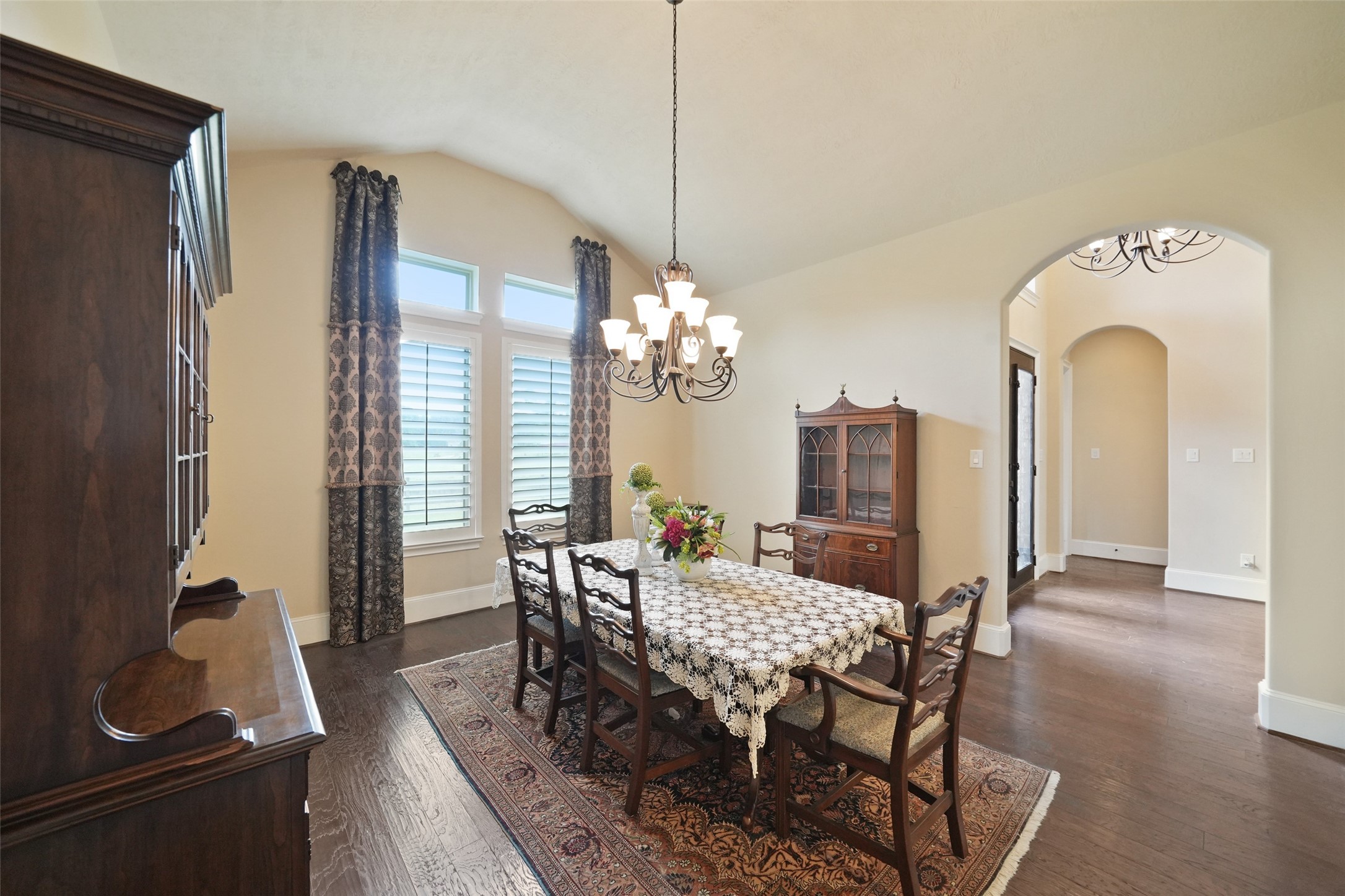 26250 A Riley Road Waller, TX 77484 - Photo 10 of 50 Elegant formal dining features arched doorways, tall windows with plantation shutters, and a graceful chandelier—ideal for gatherings.