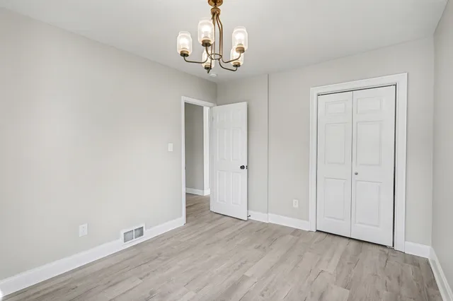 a view of a room with wooden floor and chandelier