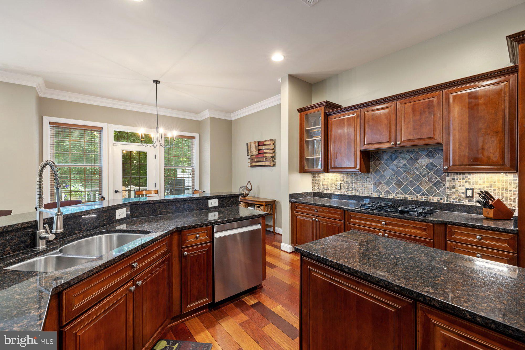 20393 Dunkirk Square Sterling, VA 20165 - Photo 23 of 96 a kitchen with stainless steel appliances granite countertop wooden cabinets stove a sink and dishwasher next to a window