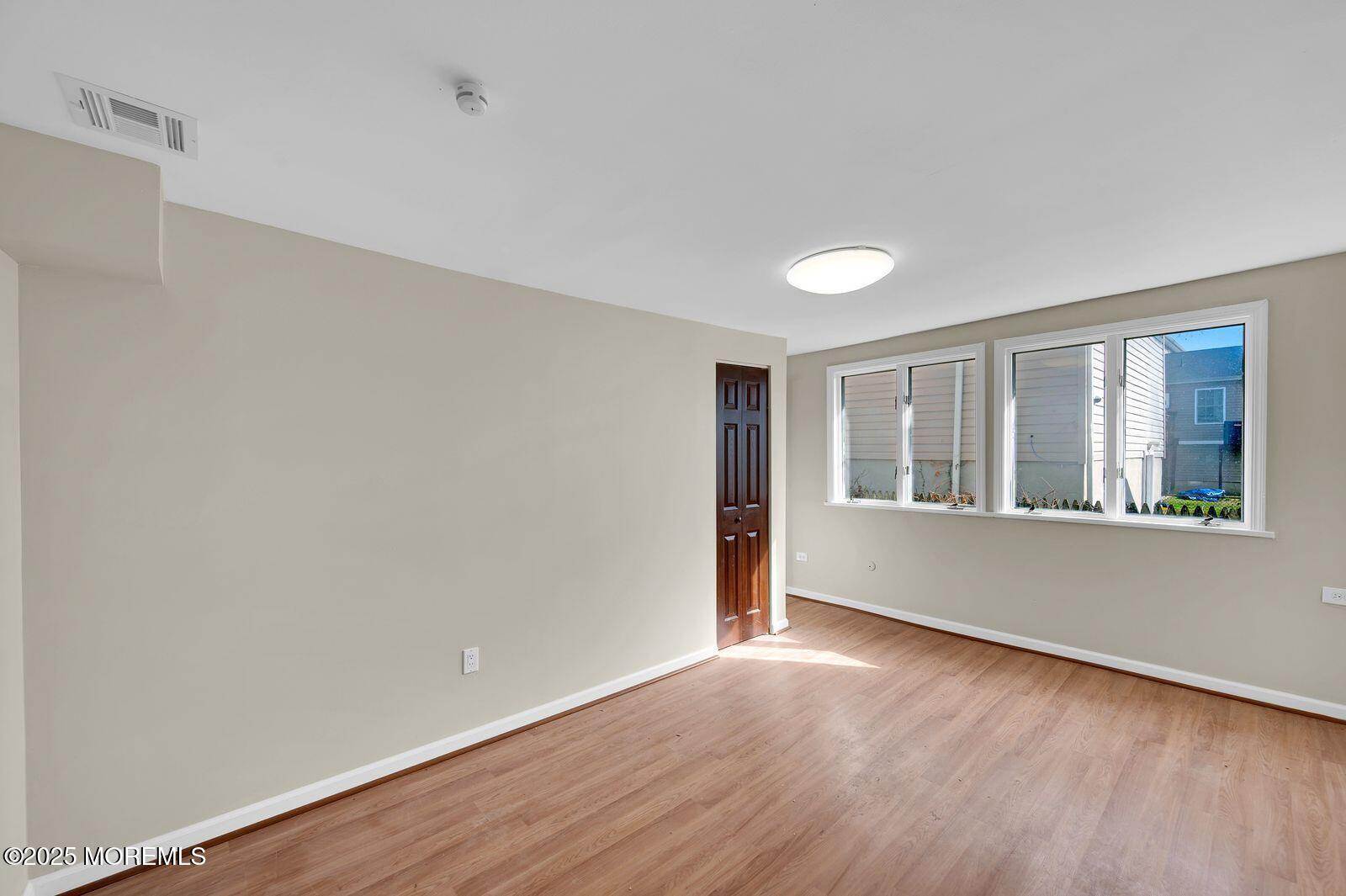32 Lakewood Avenue Keansburg, NJ 07734 - Photo 21 of 30 a view of an empty room with wooden floor and a window