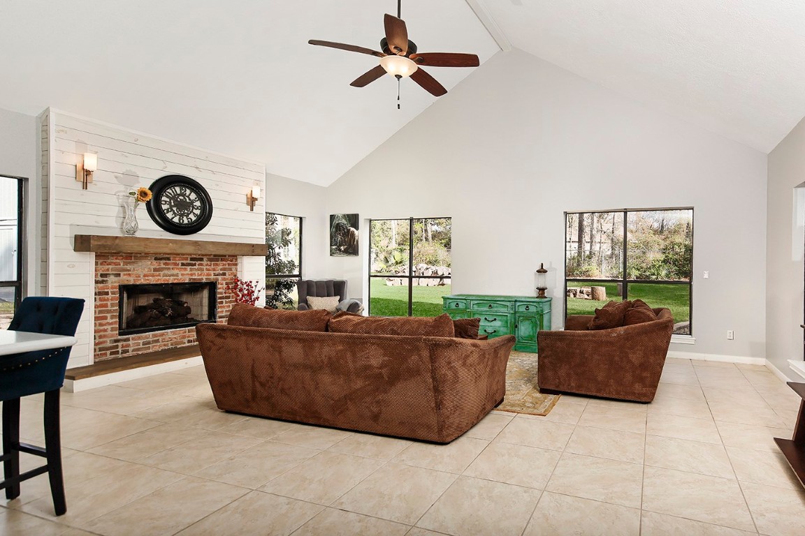 44 Lake Forest Circle Conroe, TX 77384 - Photo 13 of 49 a living room with furniture a flat screen tv and a fireplace