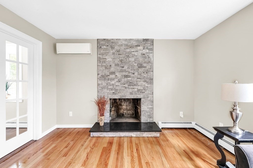 516 Old Wales Road Monson, MA 01057 - Photo 14 of 36 a living room with a fireplace and wooden floor