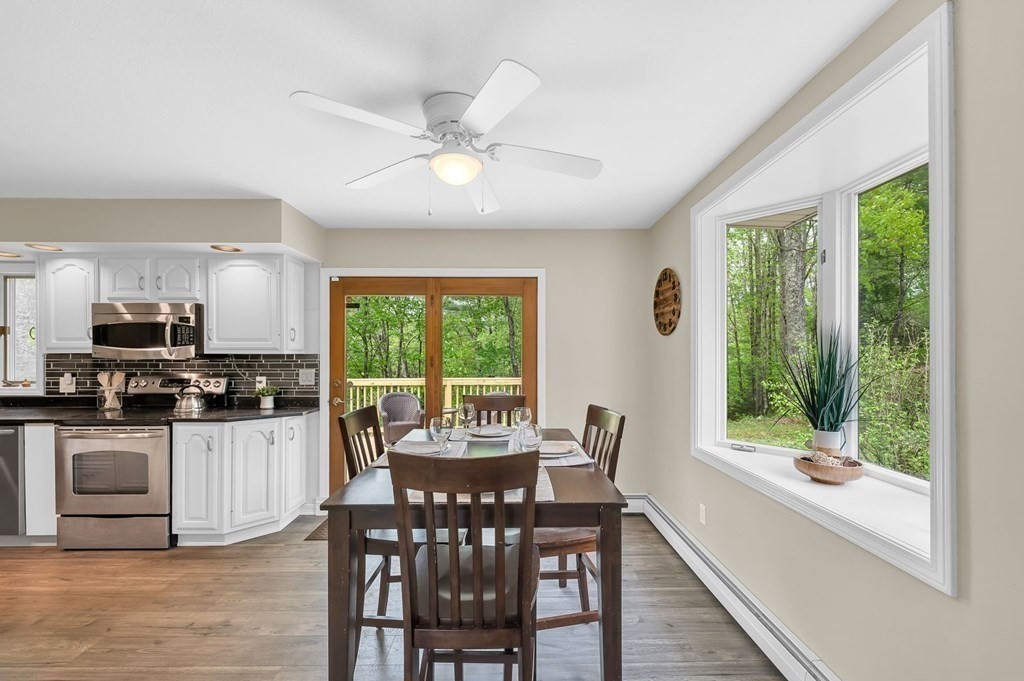 516 Old Wales Road Monson, MA 01057 - Photo 19 of 36 a dining room with wooden floor a chandelier a wooden table and chairs