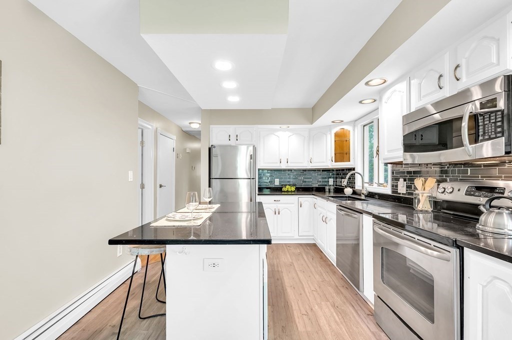 516 Old Wales Road Monson, MA 01057 - Photo 2 of 36 a kitchen with stainless steel appliances kitchen island granite countertop a refrigerator a stove a sink and white cabinets with wooden floor