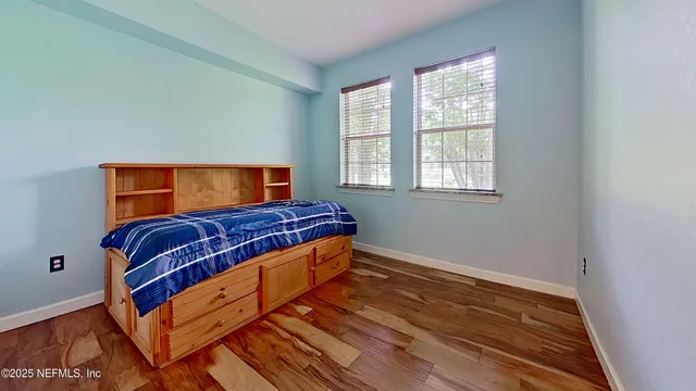 a bedroom with a bed and wooden floor