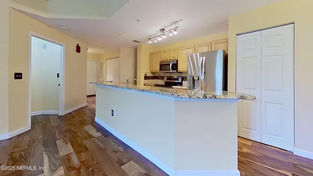 a kitchen with stainless steel appliances a refrigerator sink and microwave