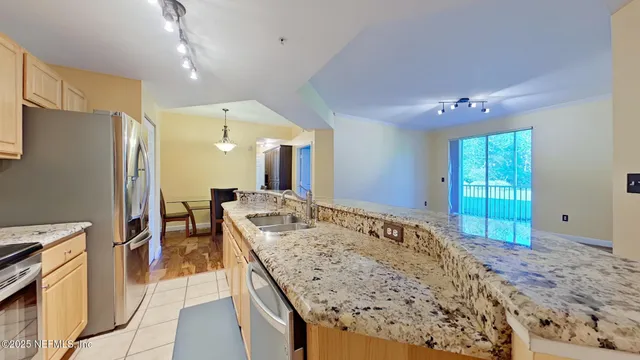 a view of kitchen island a sink wooden floor dining table and chairs