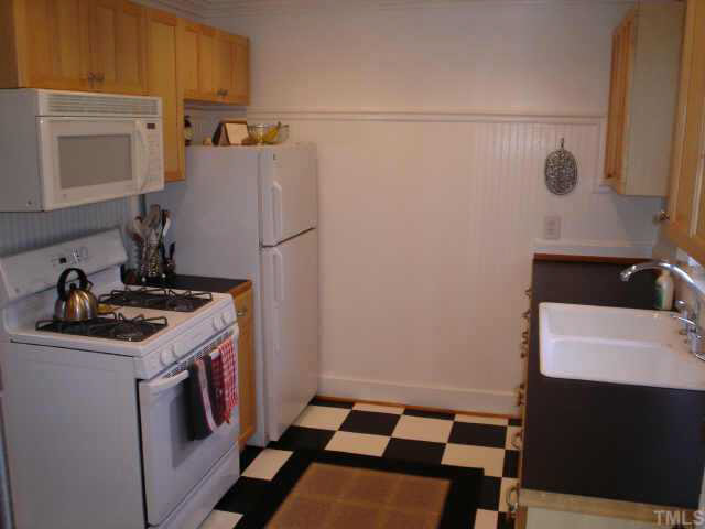 300 West Whitaker Mill Road Raleigh, NC 27608 - Photo 4 of 10 a kitchen with a sink a stove and refrigerator
