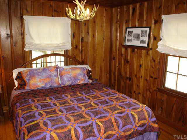 300 West Whitaker Mill Road Raleigh, NC 27608 - Photo 5 of 10 a bedroom with a bed and a chandelier