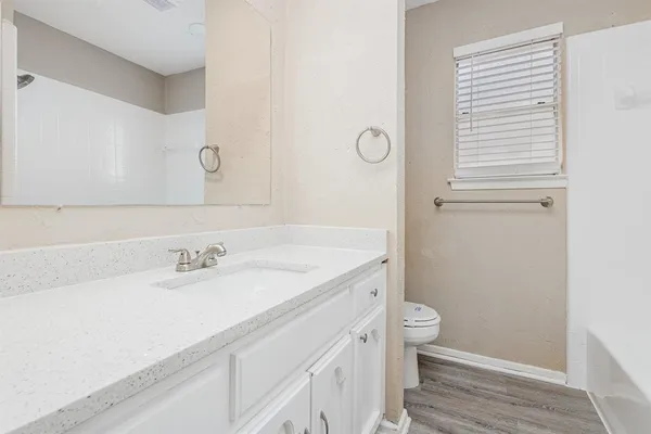 a bathroom with a sink a toilet and a mirror