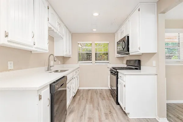 a kitchen with a sink a window a stove and a refrigerator