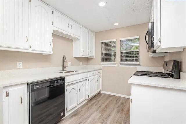 a kitchen with granite countertop white cabinets and white appliances