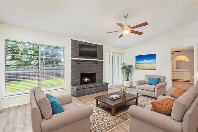 a living room with furniture a fireplace and a flat screen tv
