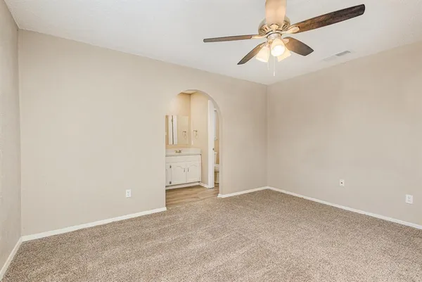 an empty room with windows and fan