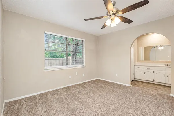 an empty room with fan and windows