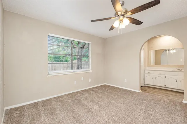 an empty room with fan and windows