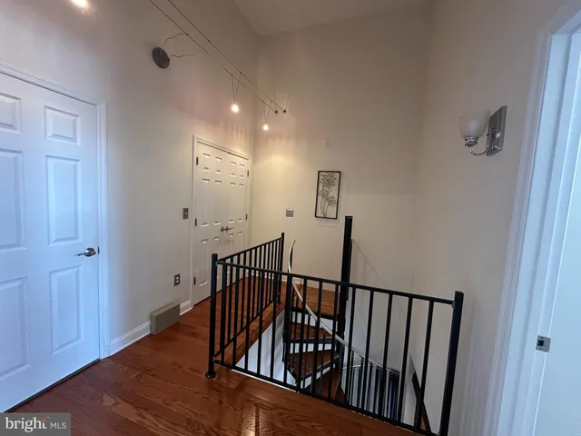 a view of staircase with railing and white walls