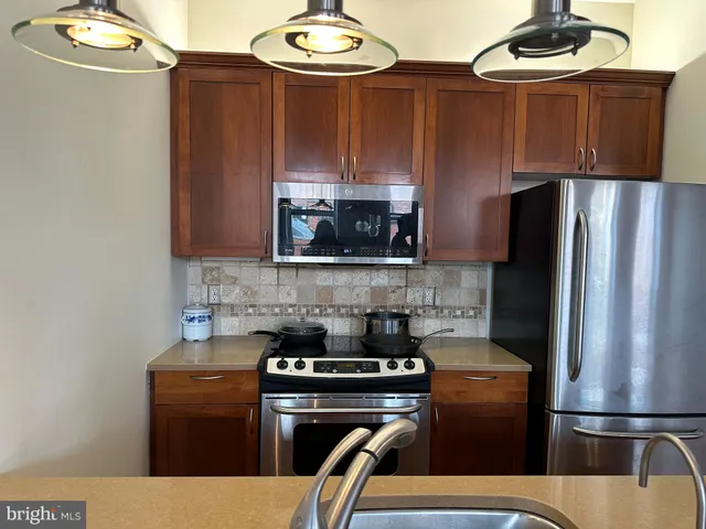 a kitchen with stainless steel appliances granite countertop a refrigerator stove and microwave