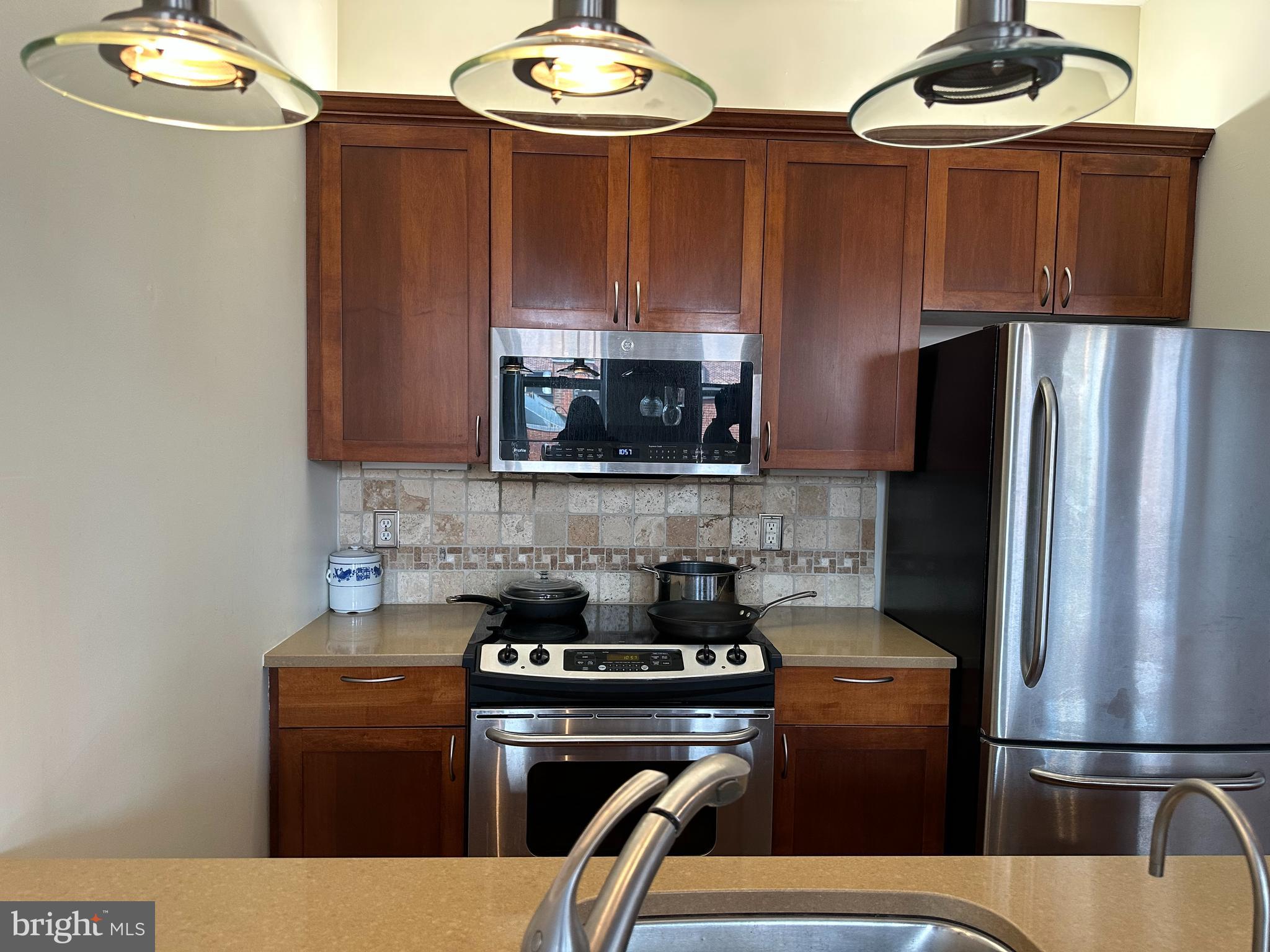 141 North 2nd Street, Unit 3C Philadelphia, PA 19106 - Photo 9 of 28 a kitchen with stainless steel appliances granite countertop a refrigerator stove and microwave