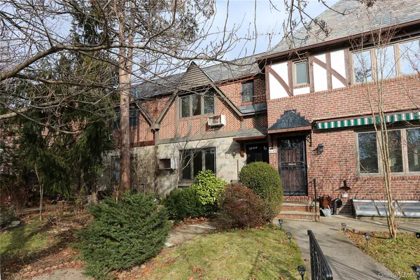 a front view of a house with garden and plants