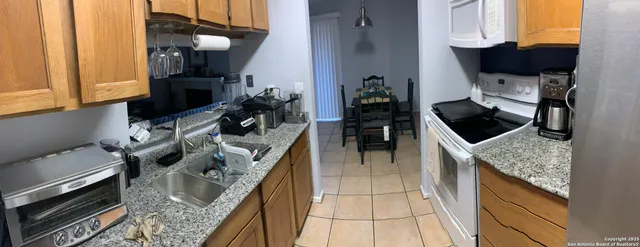 a kitchen with granite countertop a sink stove and cabinets