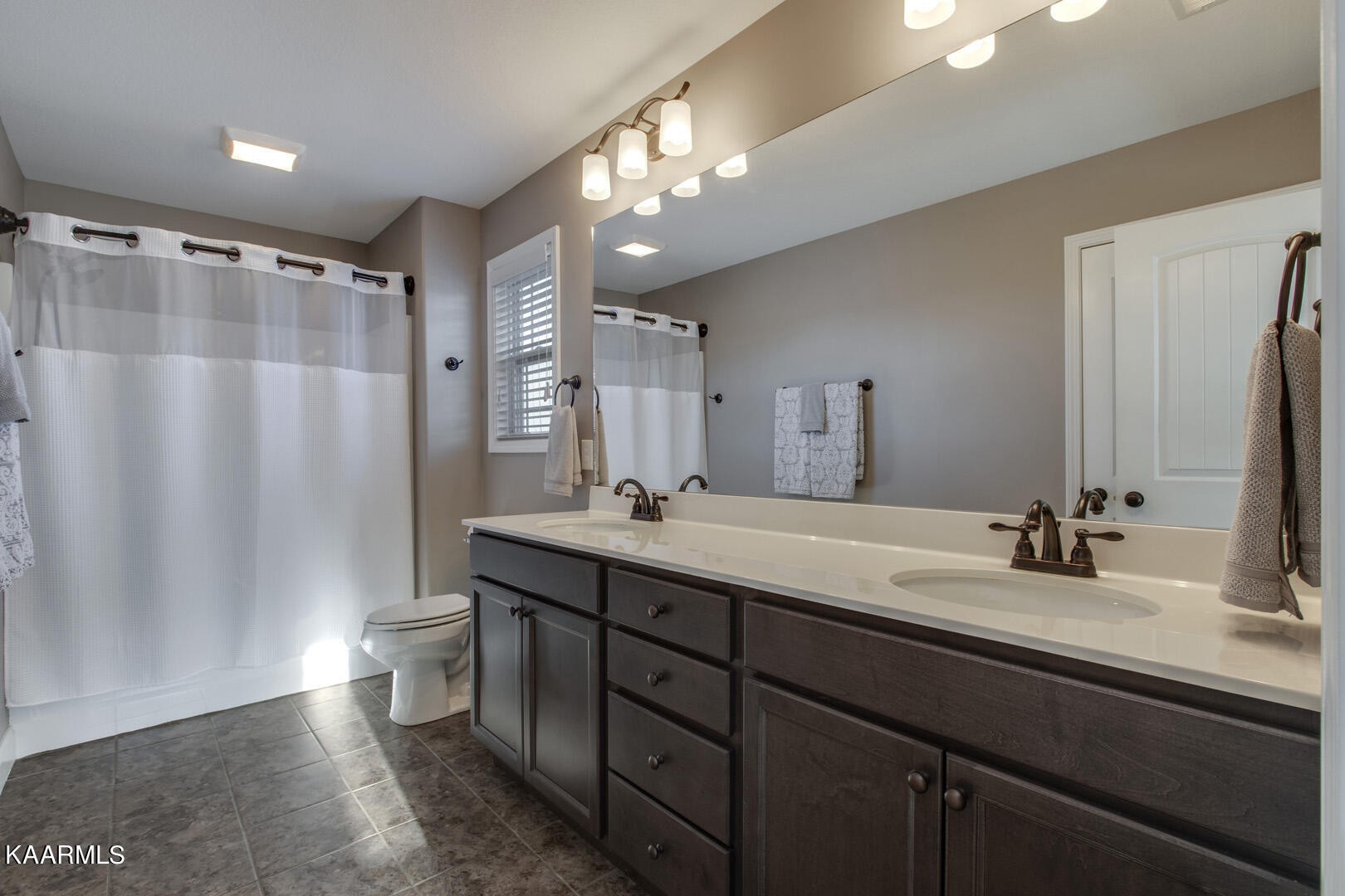 3417 Boulder Point Lane Powell, TN 37849 - Photo 20 of 31 a bathroom with double vanity sink a toilet a mirror and shower curtain
