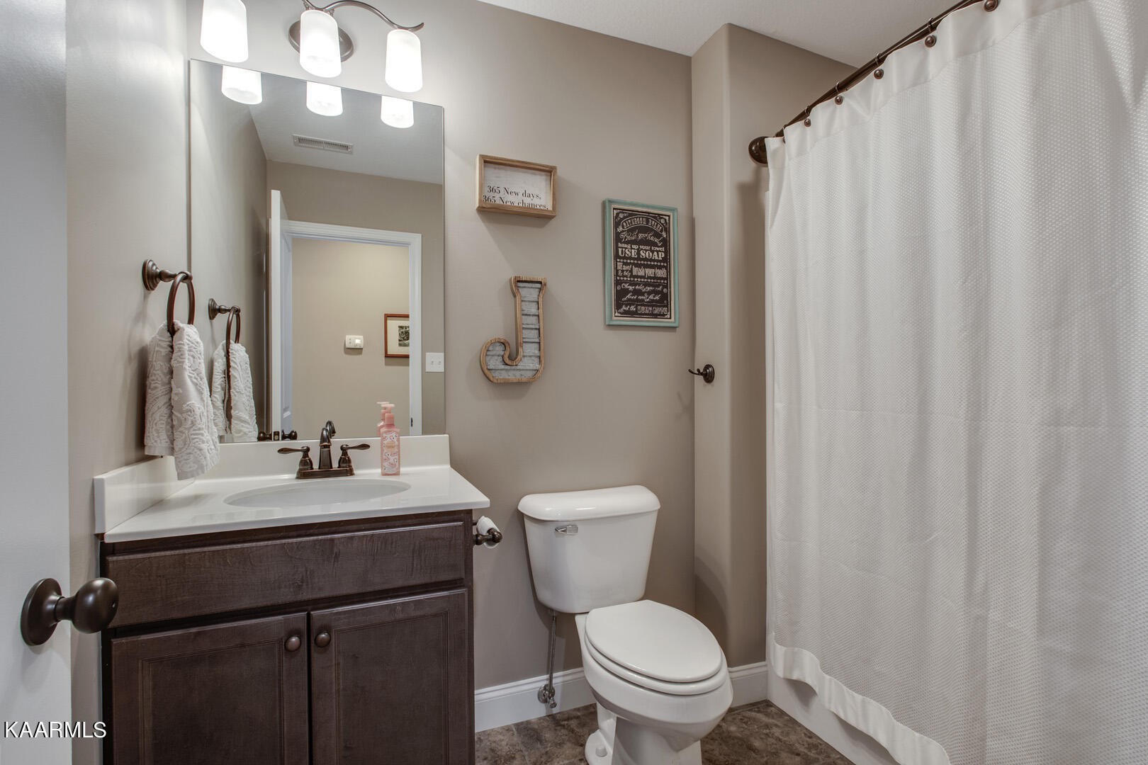 3417 Boulder Point Lane Powell, TN 37849 - Photo 24 of 31 a bathroom with a sink a toilet a mirror and shower curtain