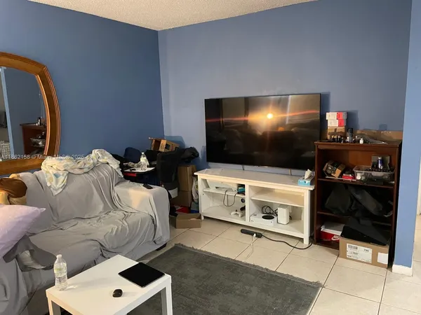 a living room with a flat screen tv and gym equipment